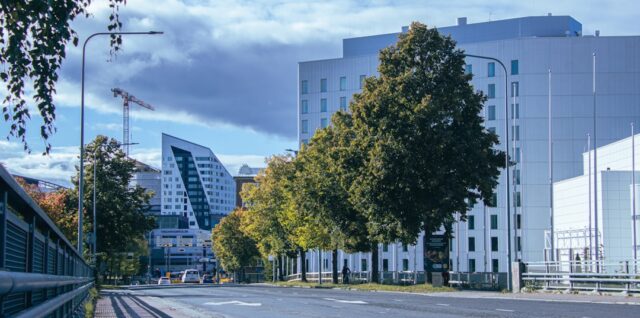 a city street lined with tall buildings and trees